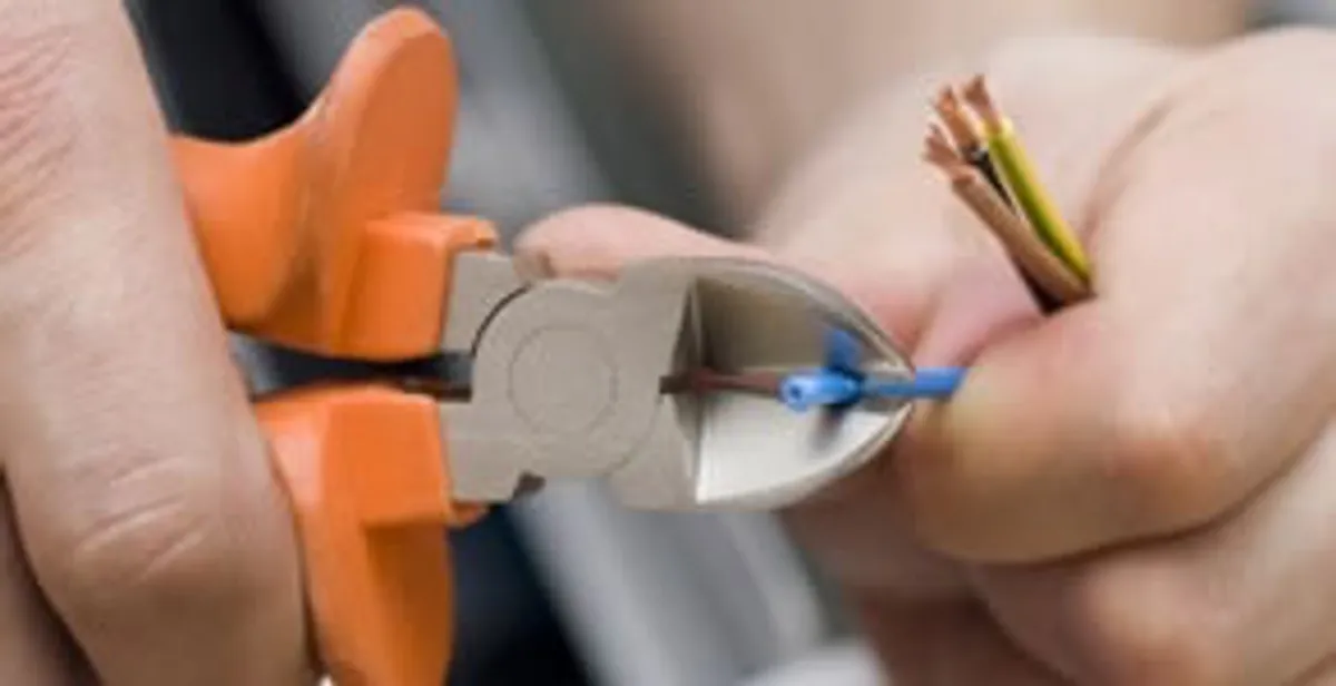 licensed electrician performing precise wire cutting and preparation during electrical service in Staten Island, NY