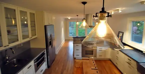 Residential electrician installing modern indoor light fixture in a home in Staten Island, NY